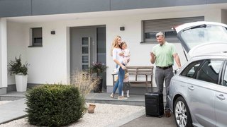 Sonnenschutz-Einbruchsschutz Familie packt die Koffer ins Auto