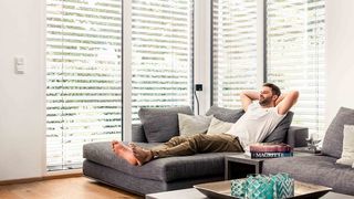 Sonnenschutz Wohnzimmer Mann liegt auf Sofa im Wohnzimmer