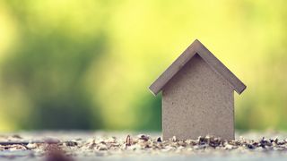 ©alexkich - stock.adobe.com Nachhaltiges Haus vor grünem Hintergrund