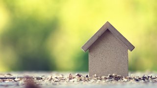 ©alexkich - stock.adobe.com Nachhaltiges Haus vor grünem Hintergrund