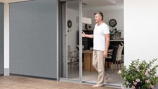 ZiP Screen mit kombinierten Insektenschutz ZiP Screen mit kombinierten Insektenschutzgitter Schieberahmen Mann öffnet Türe