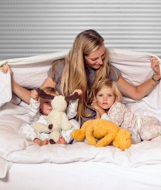 Redőnyök a hálószobában Család az ágyon a hálószobában a redőnyök előtt
