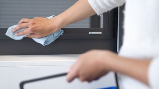 Reinigung Insektenschutzgitter Rahmen Person reinigt Insektenschutzgitter Rahmen