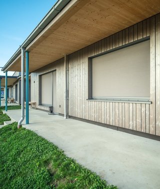 Fassade mit großen Fenstern und geschlossenem textilen Sonnenschutz