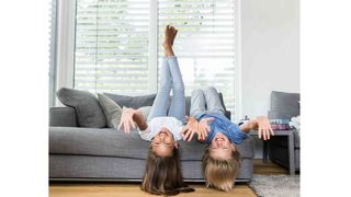 Sonnenschutz für mehr Energie Kinder liegen vor einem Raffstore am Sofa und haben Spaß