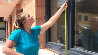 Lehrling beim Ausmessen von einem Fenster