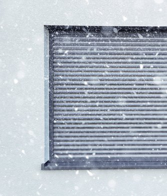 Fenster mit geschlossenem Rollladen im Winter