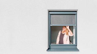 Blinos Rollo Aussenansicht Frau öffnet Blinos Rollo auf heller Fassade